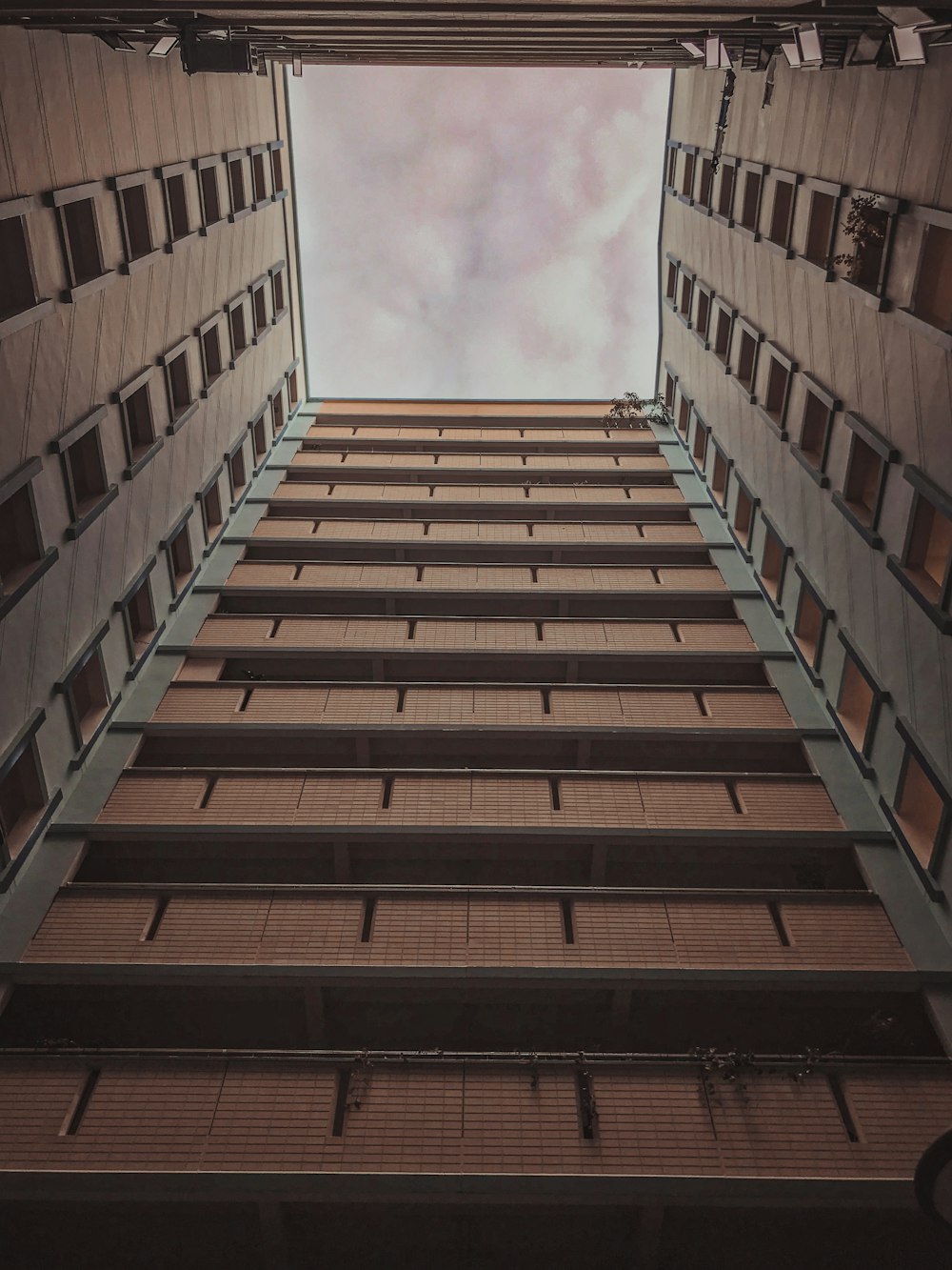 Fotografía de ángulo bajo de un edificio de hormigón marrón bajo el cielo azul durante el día