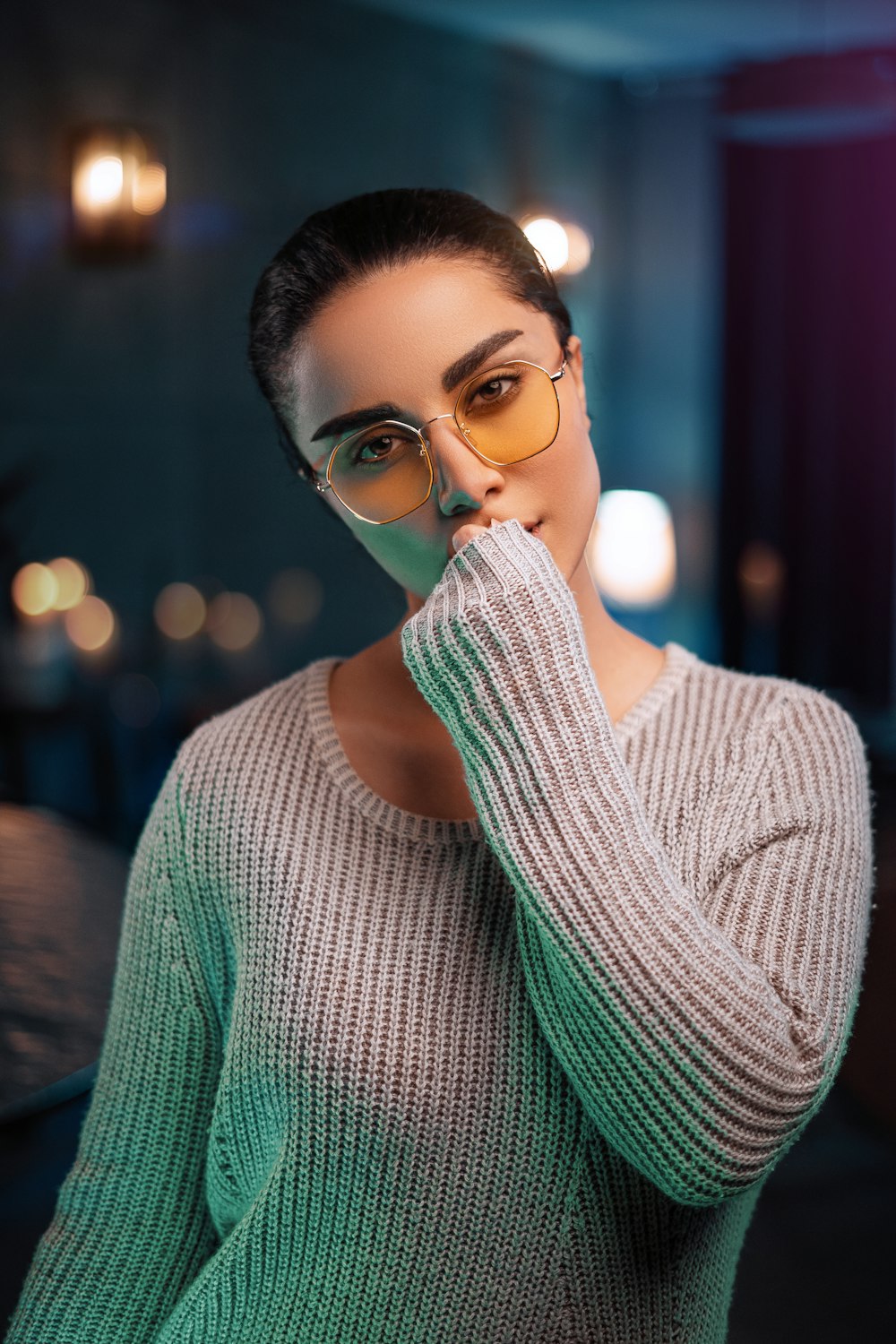woman in green knit sweater wearing eyeglasses