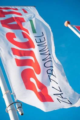 Close-up of a sleek, professionally printed advertising flag with bold branding.