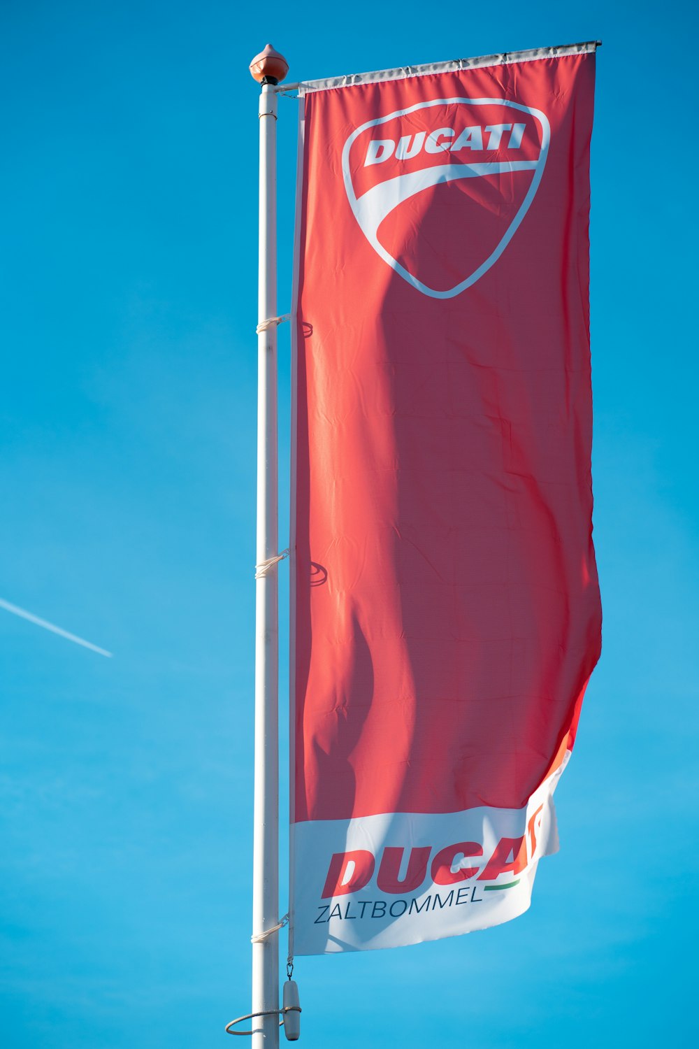 Bandera roja y blanca bajo el cielo azul durante el día