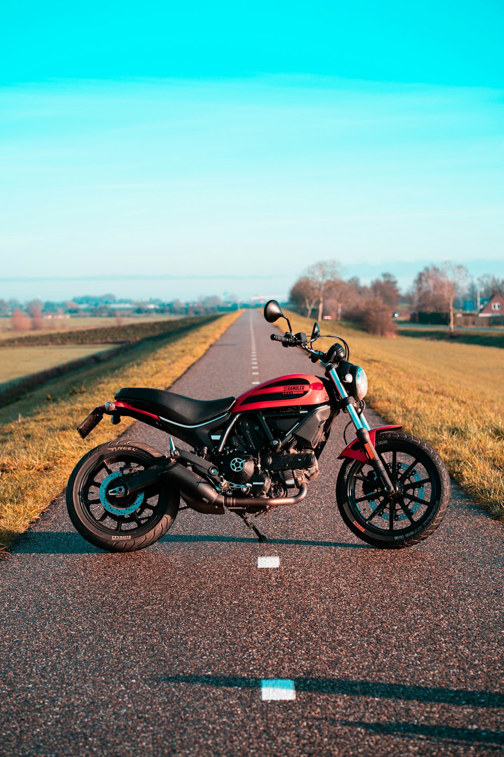 moto noire et rouge sur la route pendant la journée