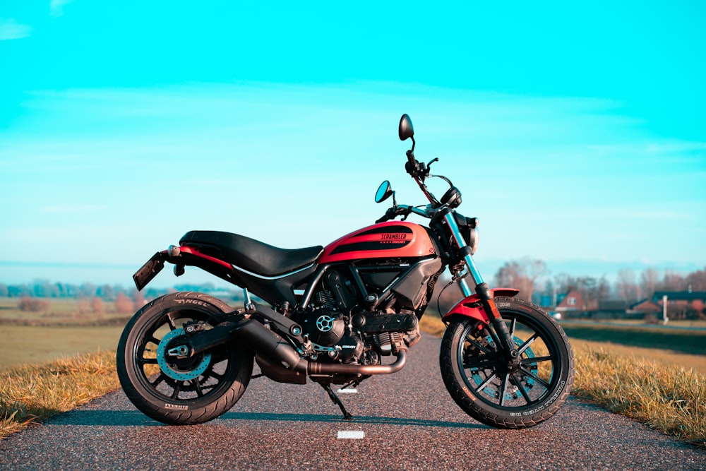 red and black motorcycle on gray asphalt road during daytime