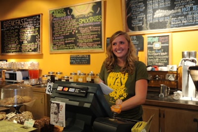 A smiling customer receiving their printed order at the counter.