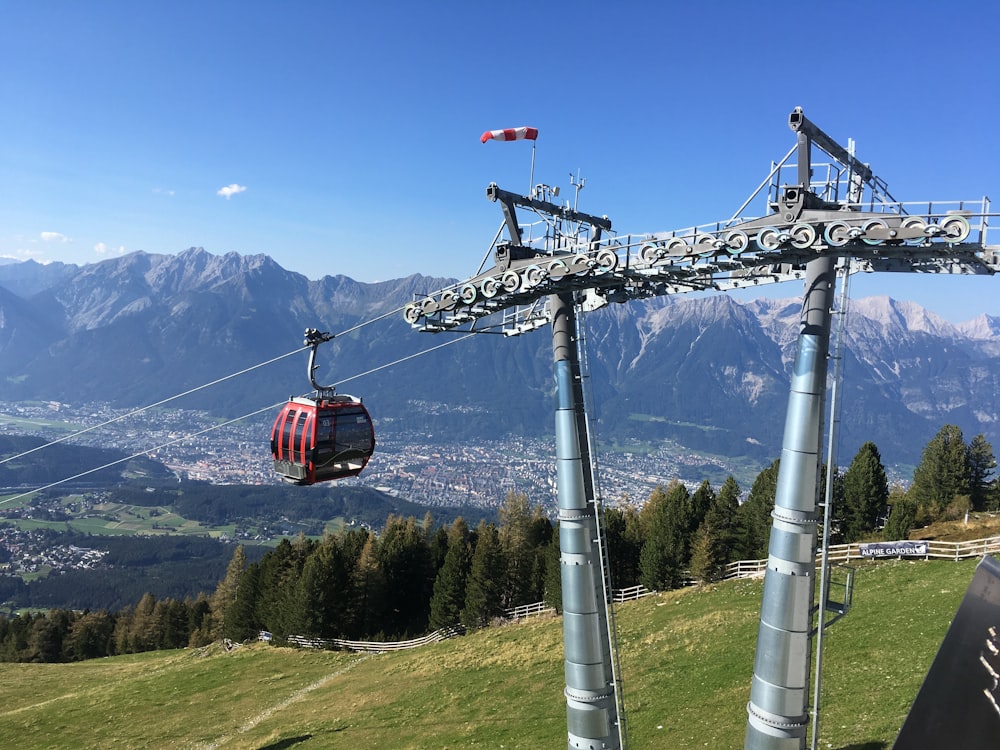 red cable car over green grass field during daytime