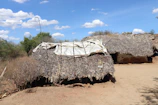 A row of labor hutments with durable design, arranged neatly on a dusty site under a clear sky.