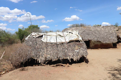A row of labor hutments with durable design, arranged neatly on a dusty site under a clear sky.