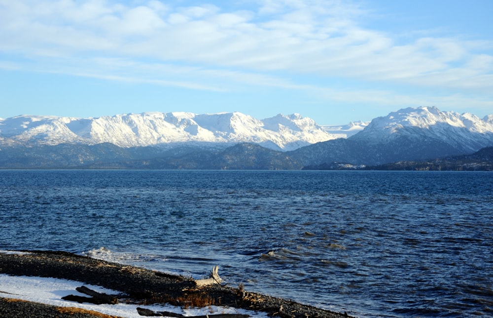 body of water near mountain during daytime