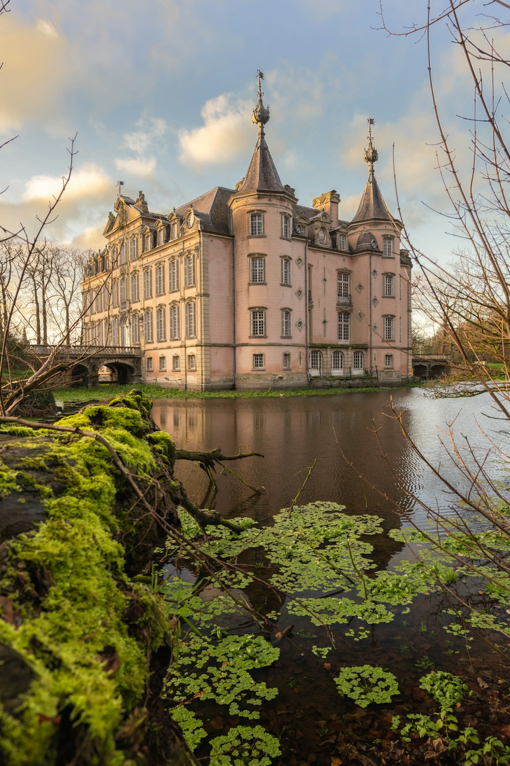 Bâtiment en béton brun et gris à côté d’un plan d’eau pendant la journée