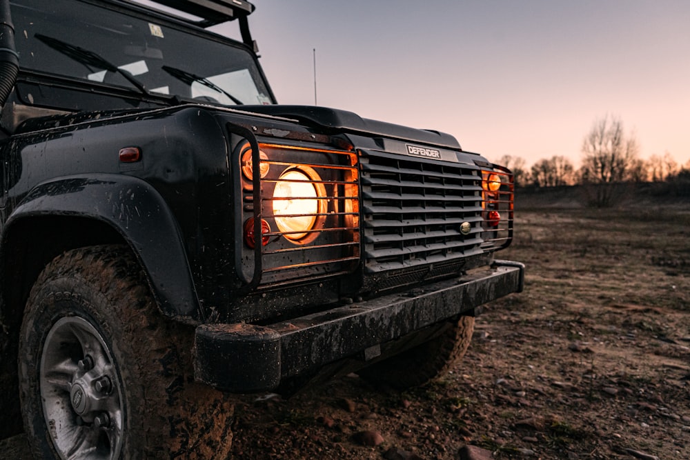 Jeep Wrangler noir sur un chemin de terre brun pendant la journée