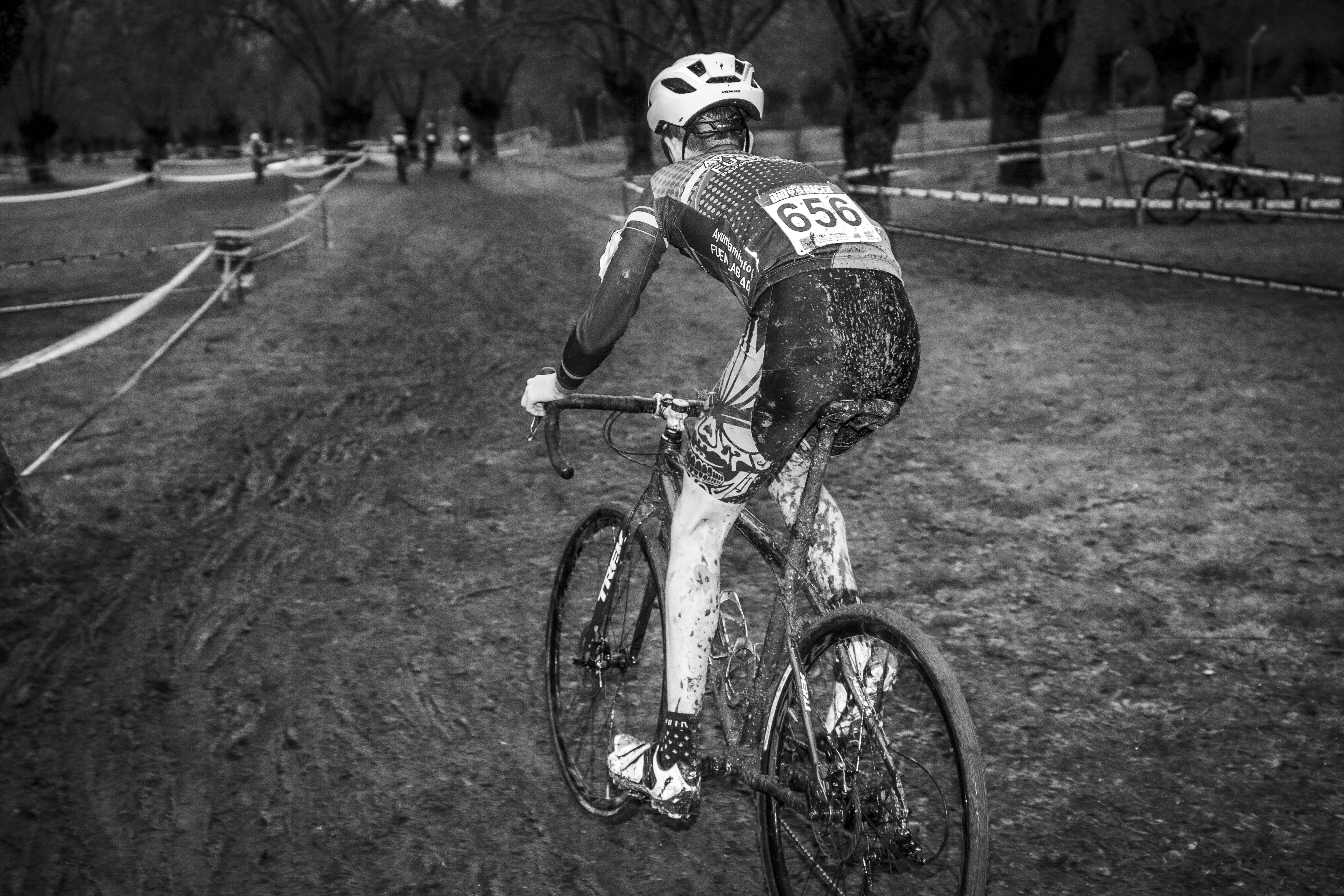 grayscale photo of man riding bicycle