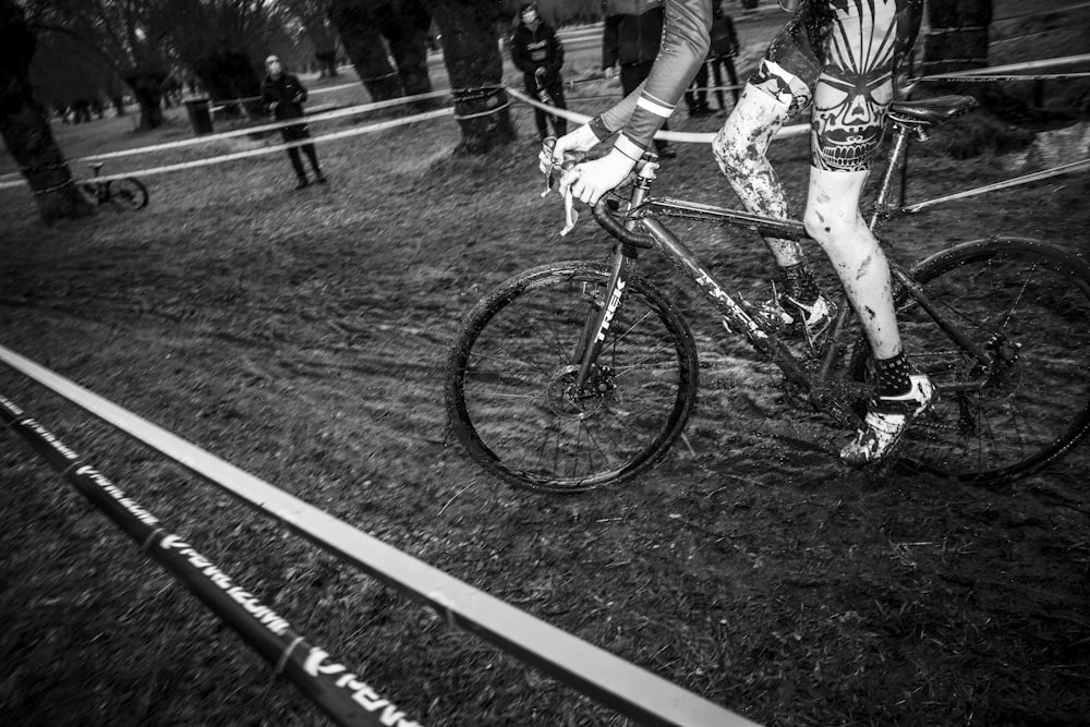 grayscale photo of man riding bicycle