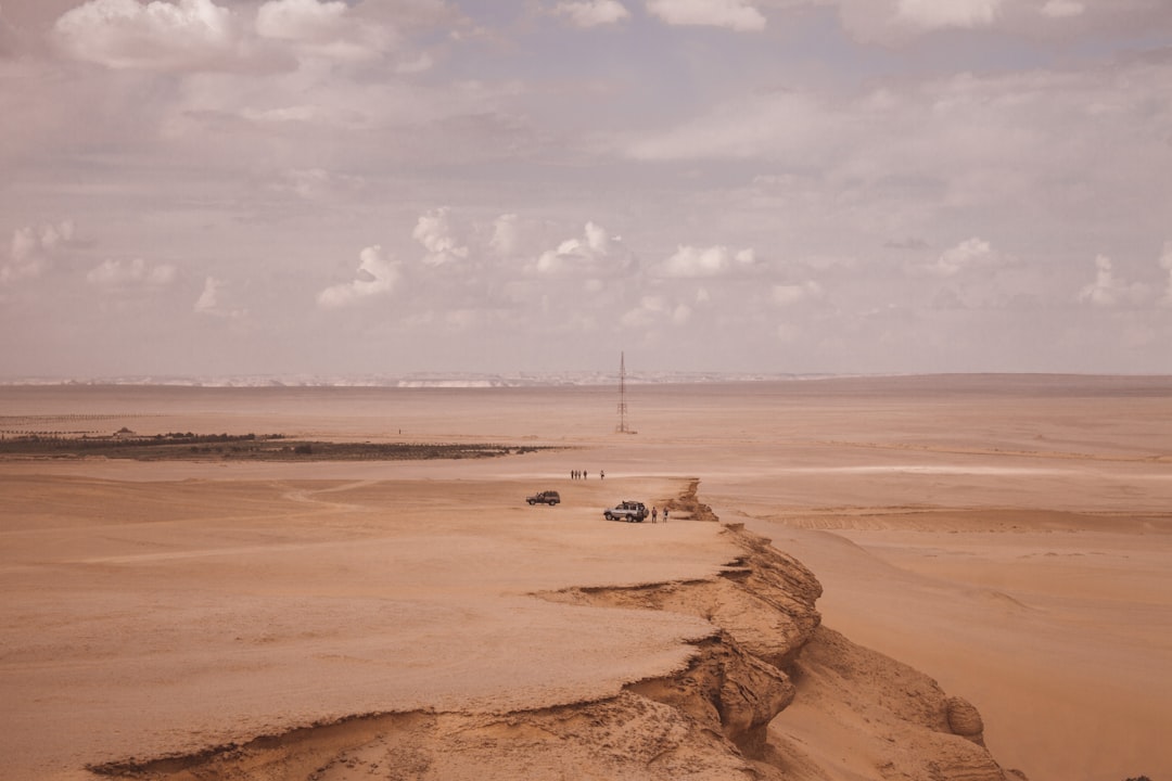 white boat on brown sand near body of water during daytime