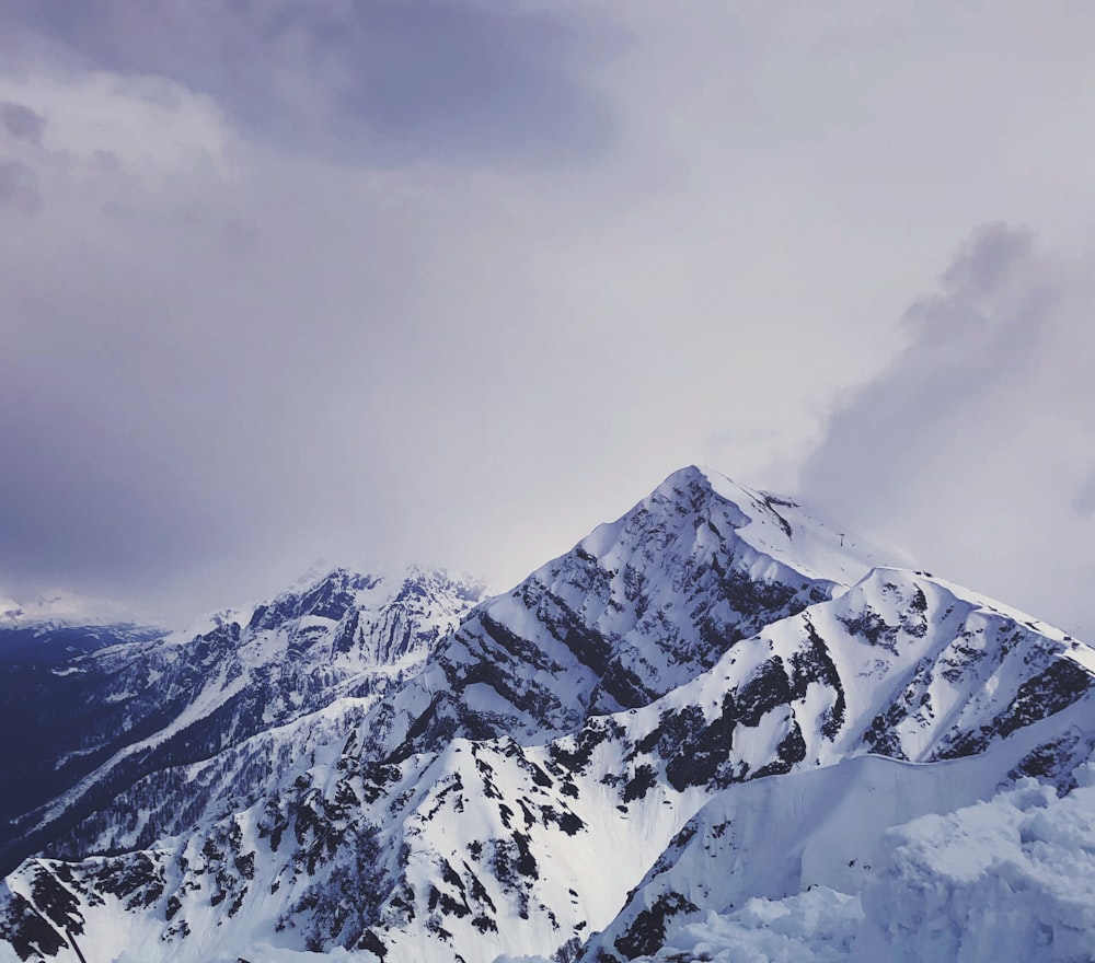 a snowboarder is standing on the top of a snowy mountain