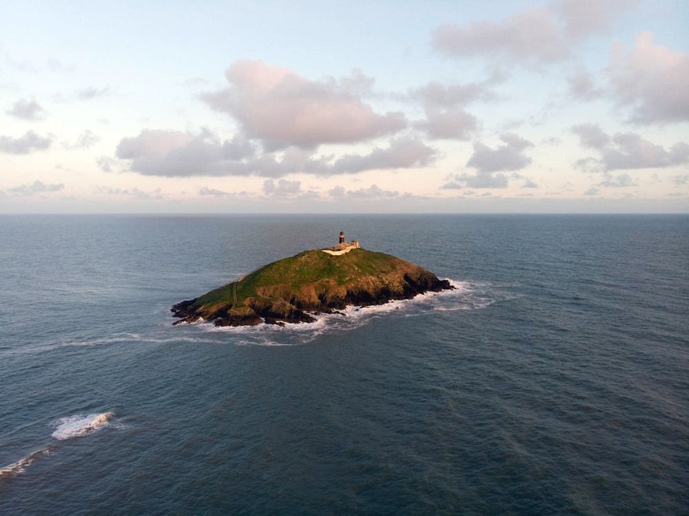 green and brown island under white clouds and blue sky during daytime