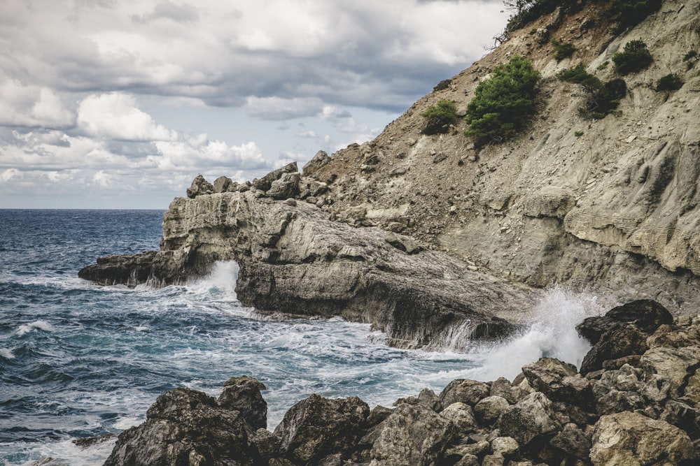 ocean waves crashing on rocky shore during daytime