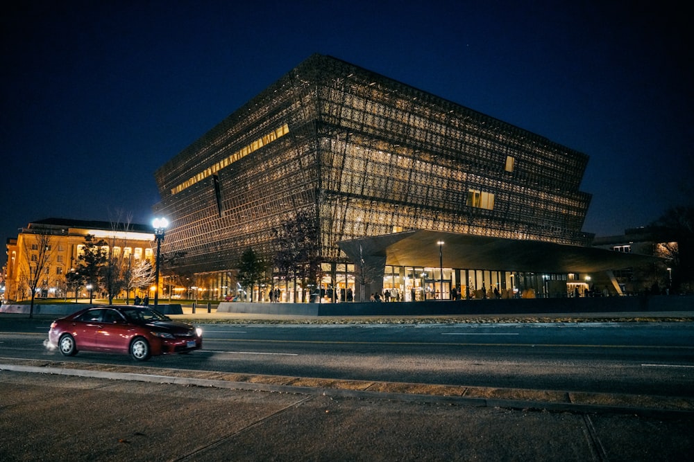 red car parked near building during night time