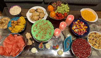 A colorful birthday party table with balloons, cakes, and a variety of tasty snacks arranged for guests.