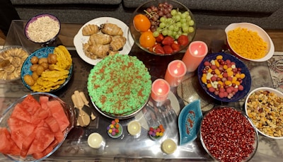 A festive birthday table set with a variety of homemade finger foods and desserts.