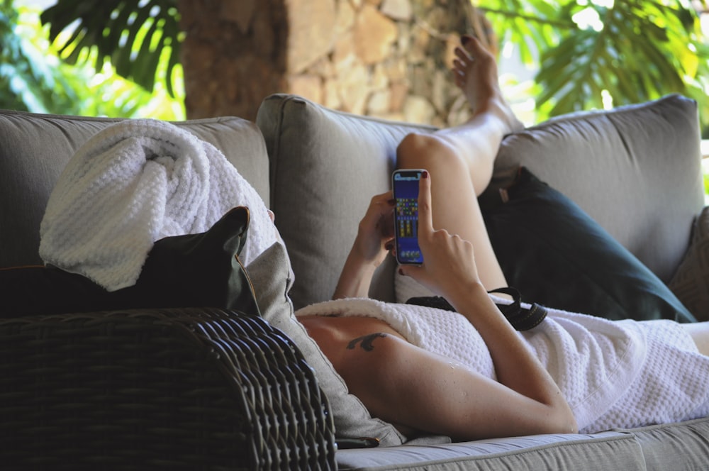 woman in white shirt lying on couch