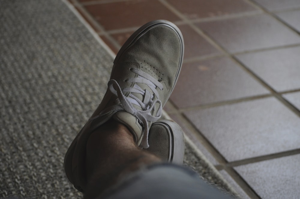 person wearing gray nike sneaker