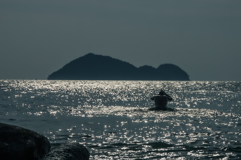 silhouette of mountain beside sea during daytime