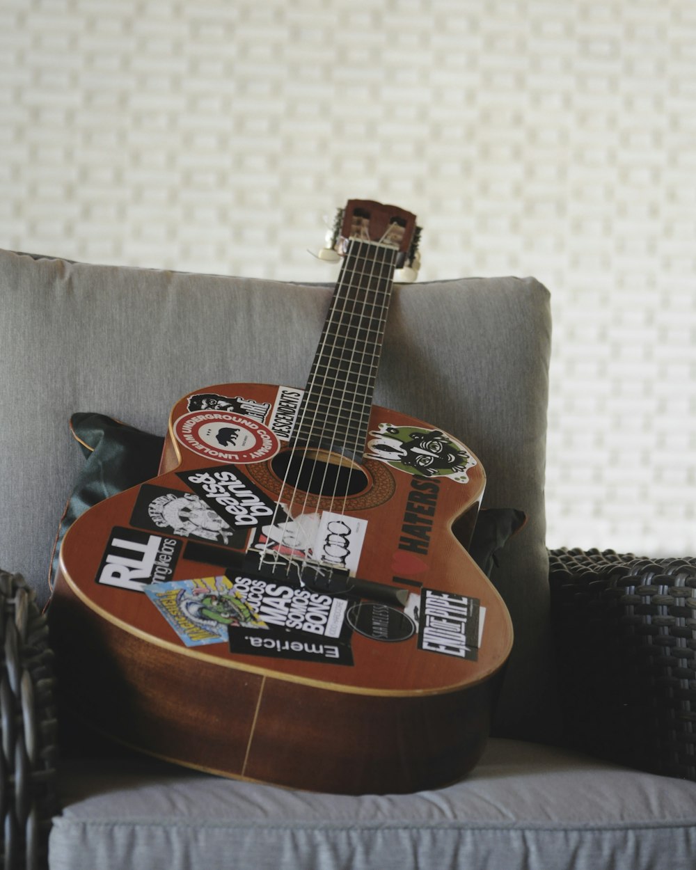 brown and black acoustic guitar on black and white textile