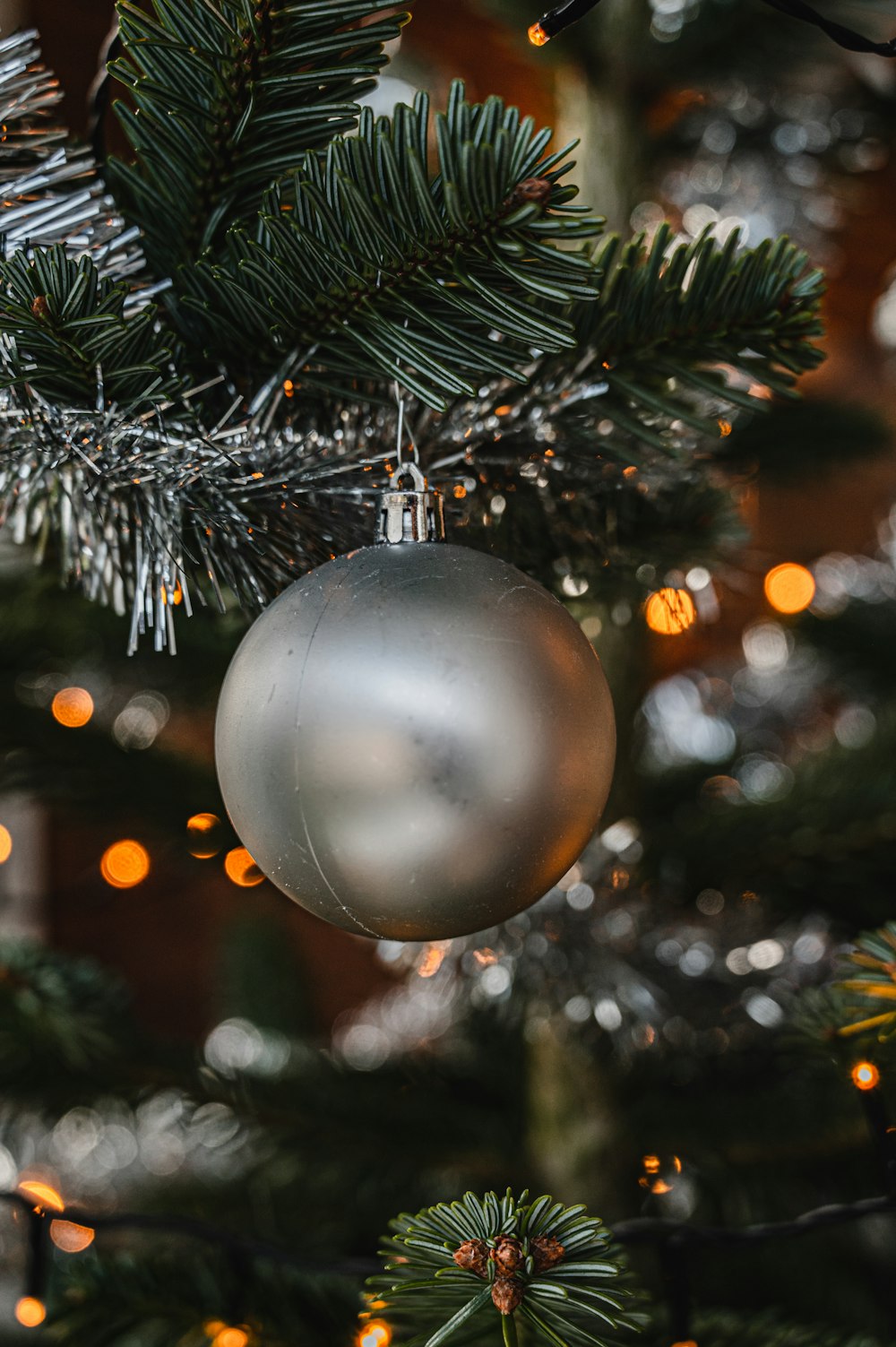 Bola de Navidad de plata sobre pino verde
