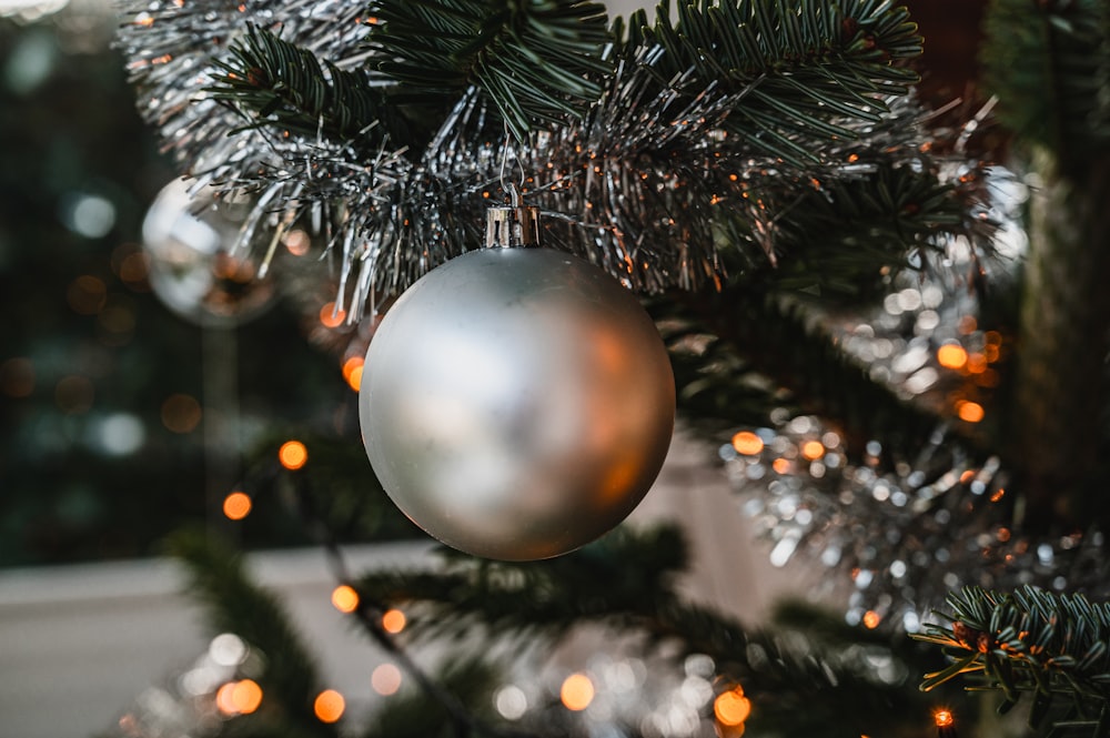 Bola de Navidad de plata en el árbol de Navidad verde