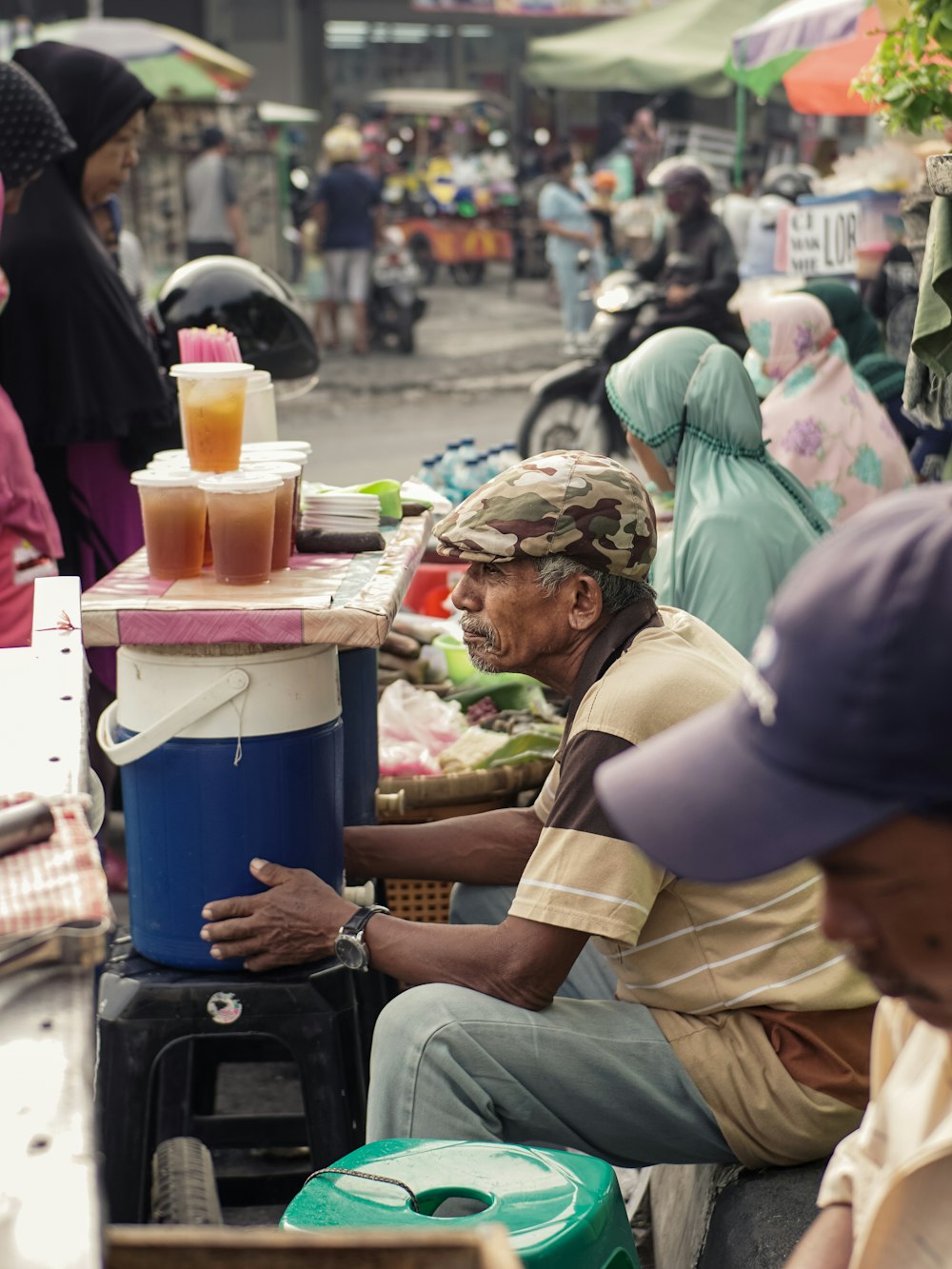 people sitting on chair near blue plastic container during daytime