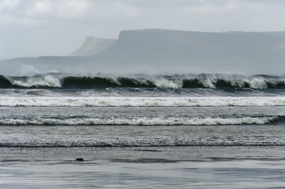 ocean waves crashing on shore during daytime