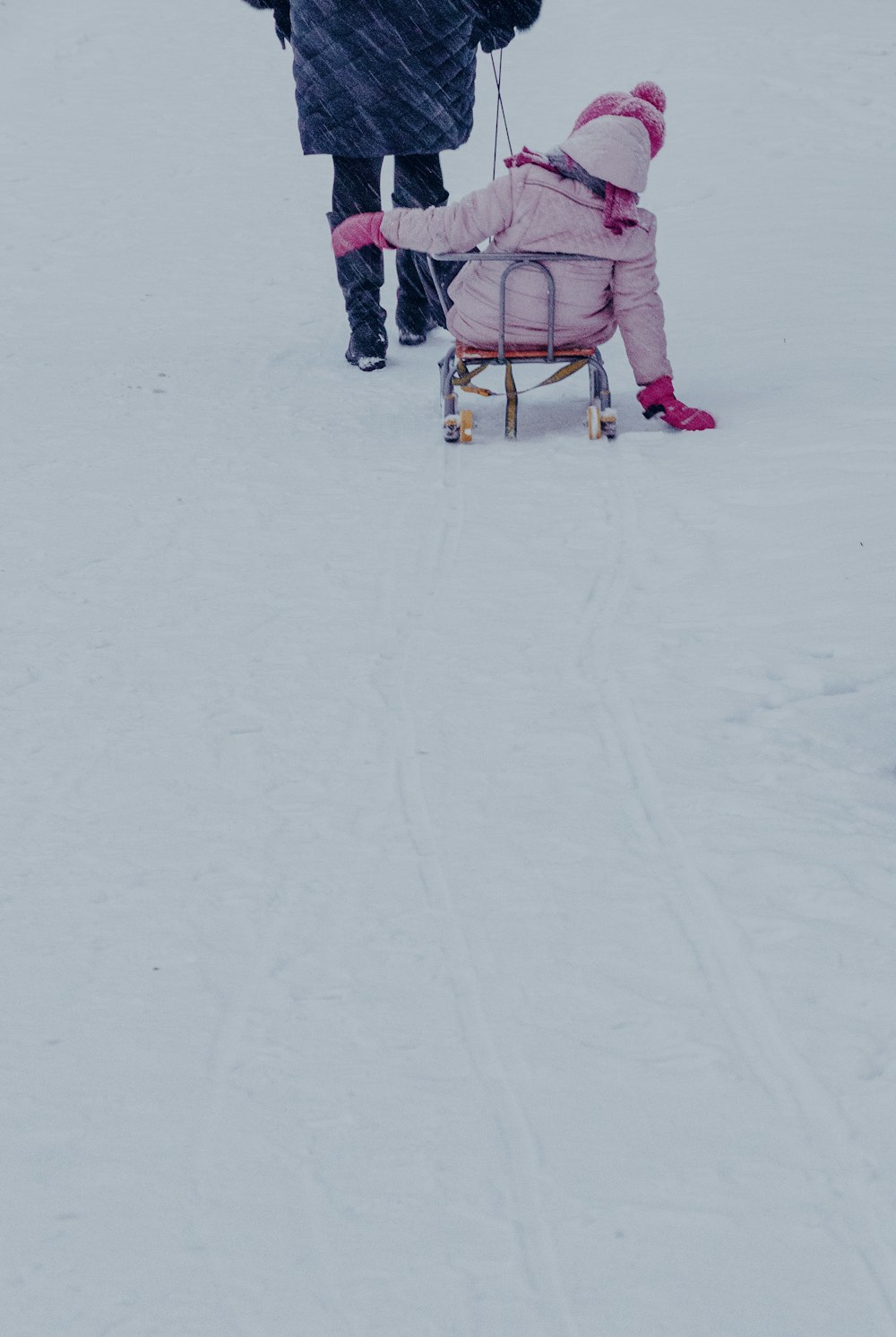 2 person walking on snow covered ground during daytime