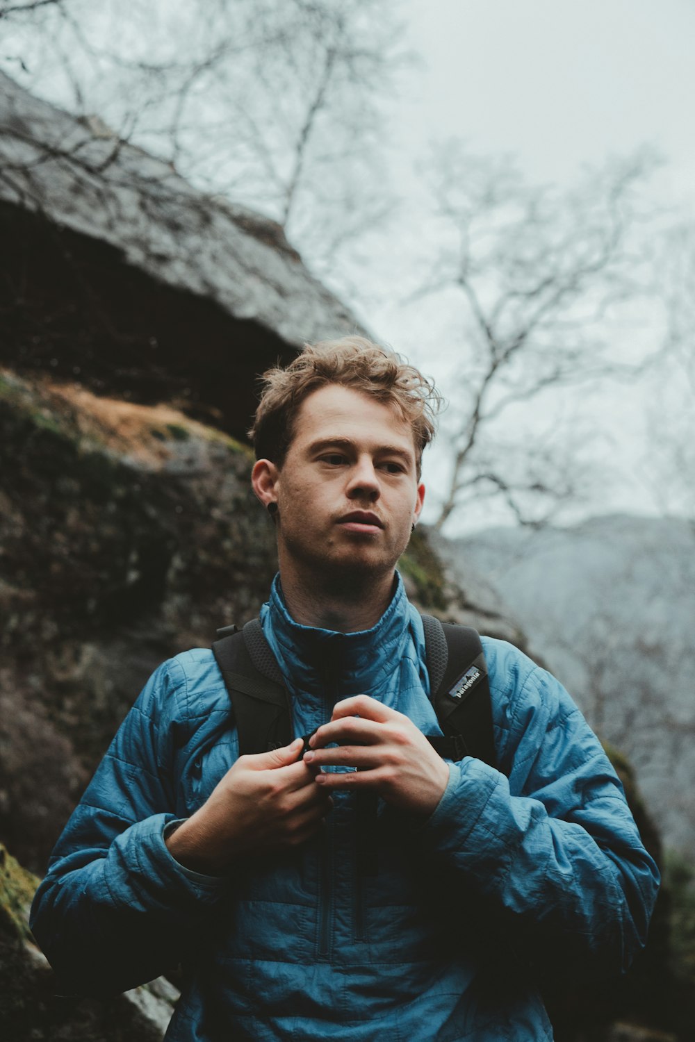 man in blue jacket standing near white tree during daytime