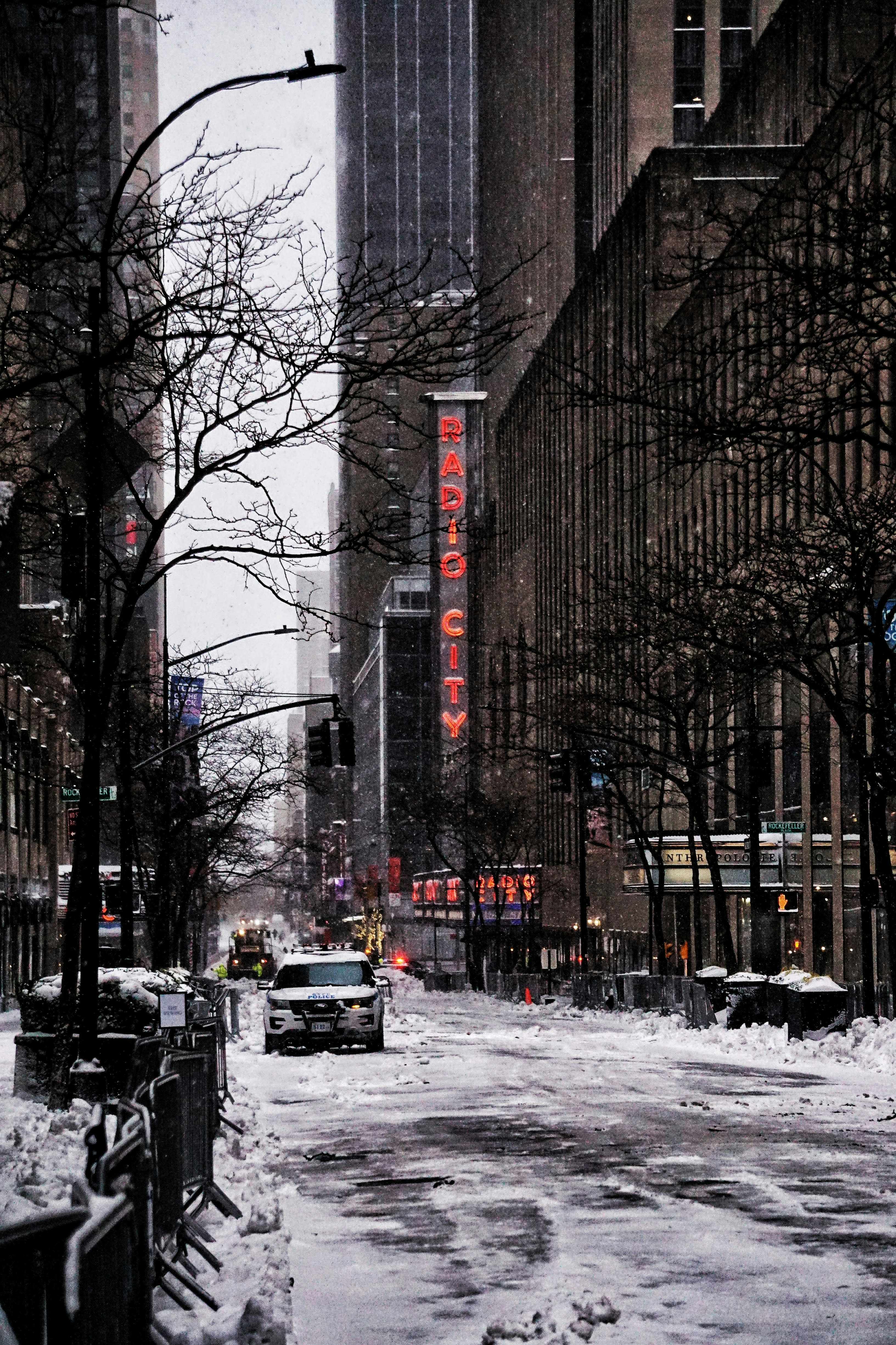 cars on road between high rise buildings during daytime