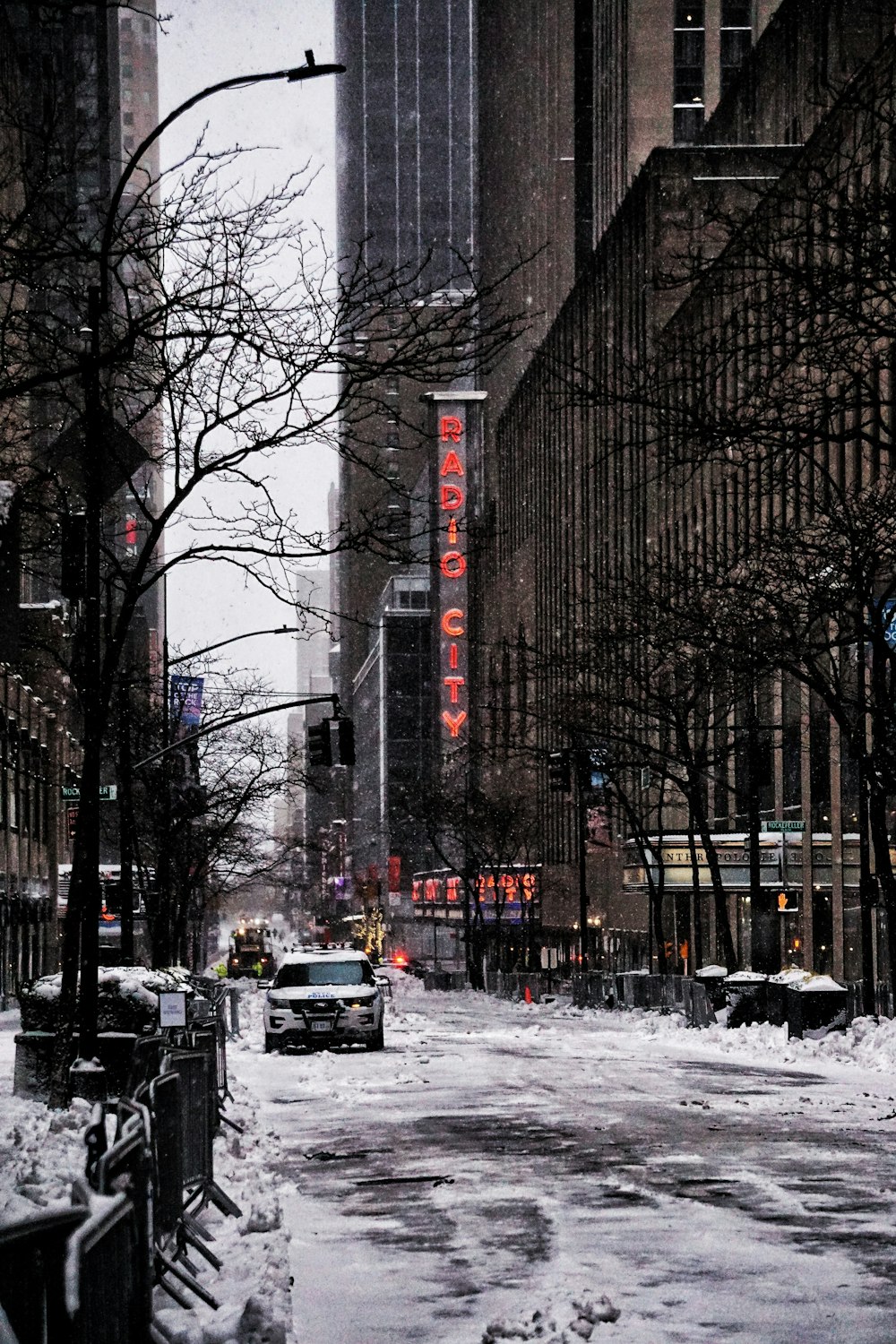 cars on road between high rise buildings during daytime