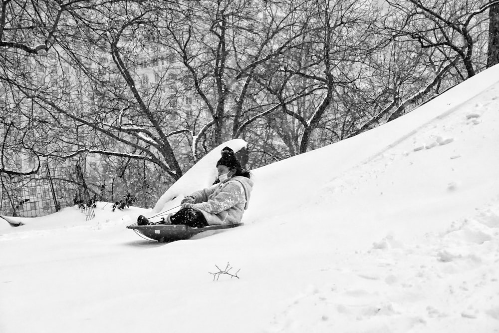 person in white jacket lying on snow covered ground during daytime