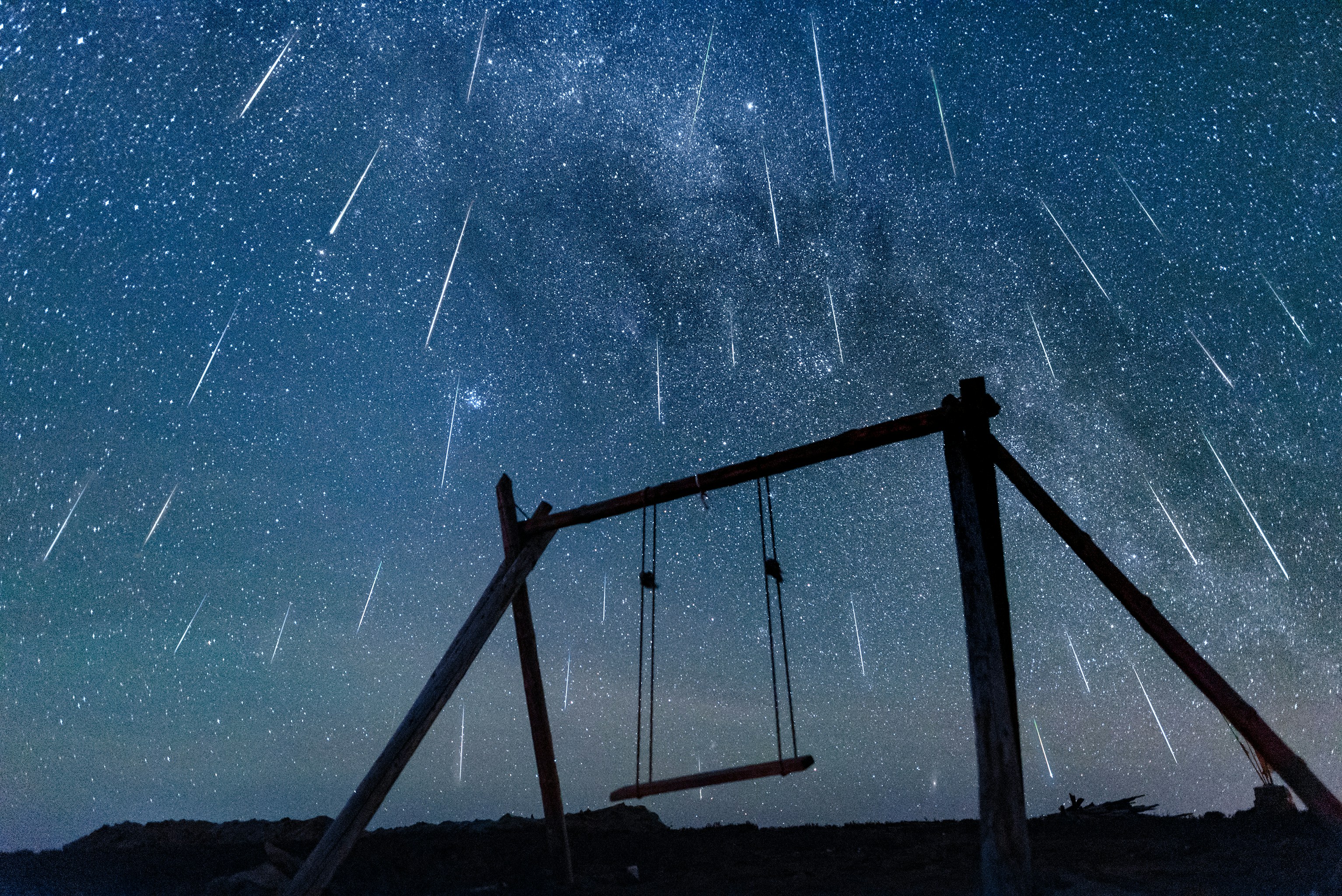 brown wooden swing under starry night