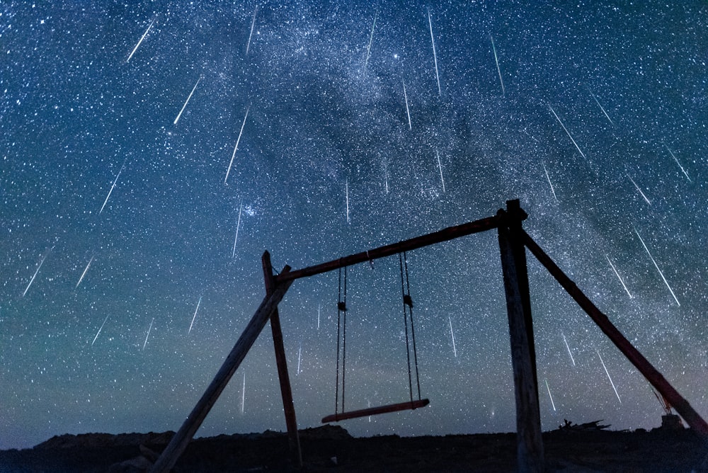 brown wooden swing under starry night