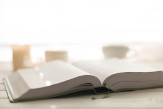 A peaceful scene of an open Bible with a candle beside it.
