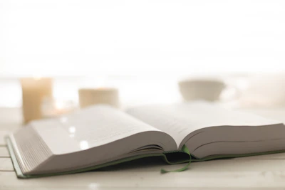 A peaceful scene of an open Bible with a candle beside it.
