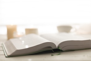 Soft candlelight illuminating an open book of prayers with a peaceful background.