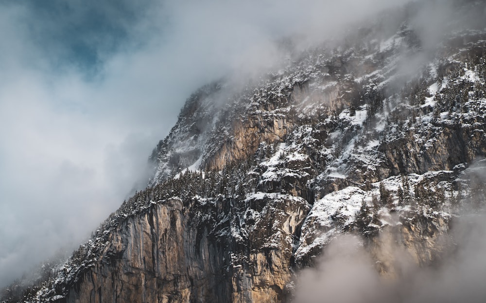 brown and white rocky mountain under white clouds and blue sky during daytime