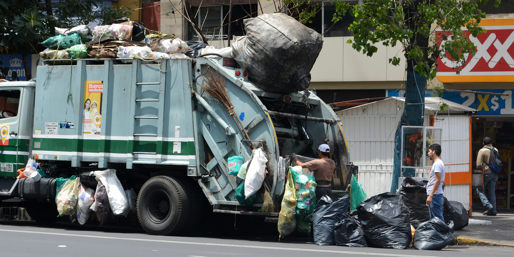 Collection crew member beside a refuse truck at work