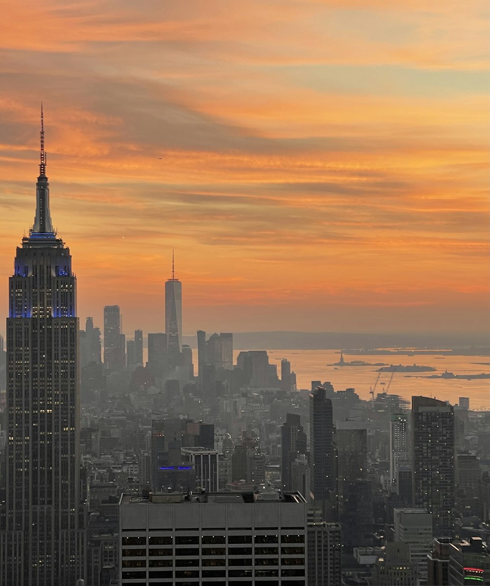 skyline della città sotto il cielo arancione e blu durante il tramonto