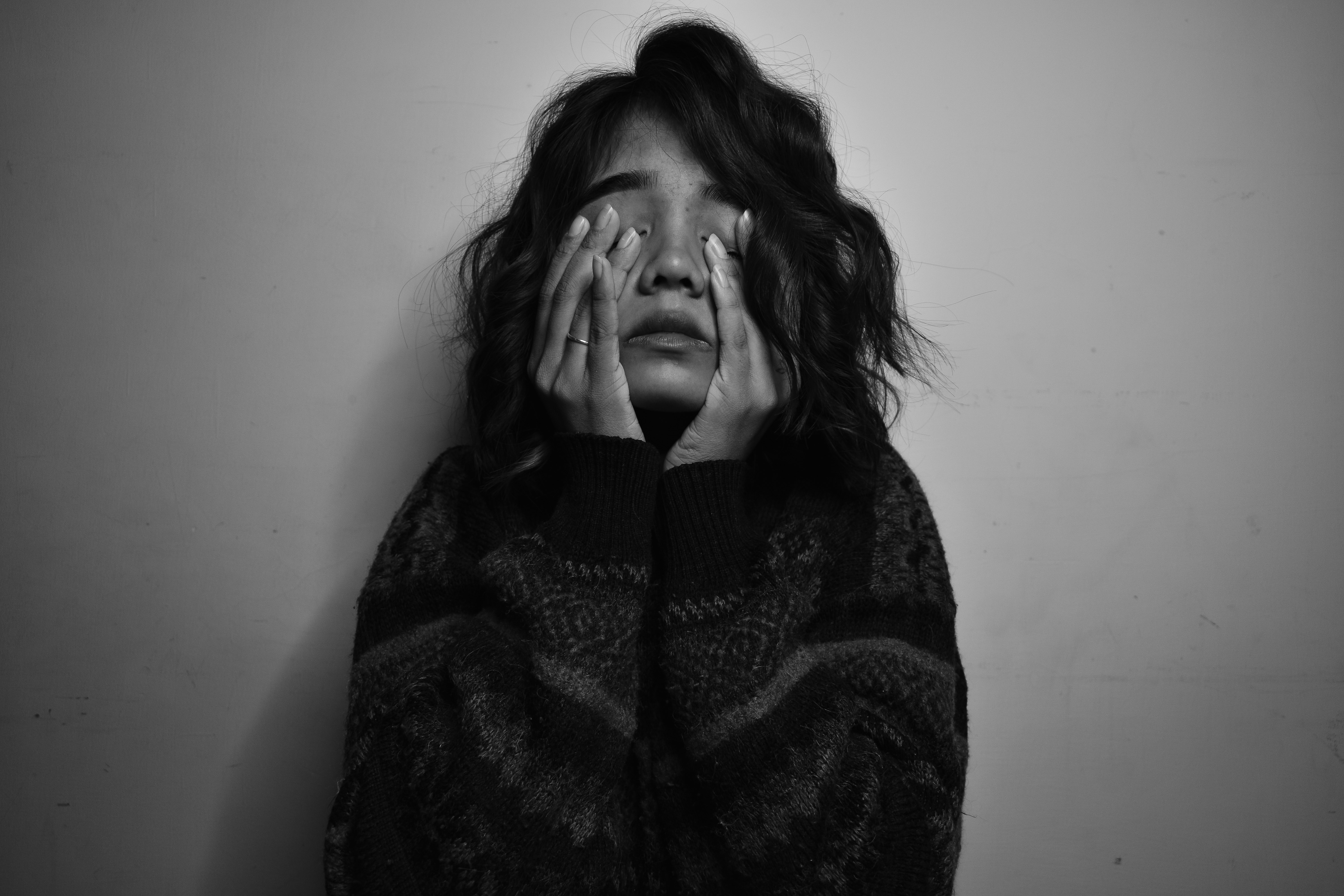 woman covering her face with her hand