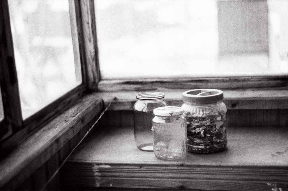 grayscale photo of clear glass jar with lid