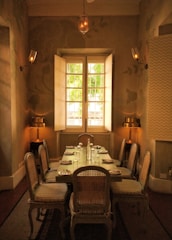 Elegant dining set with wooden chairs and a rustic table bathed in soft natural light.