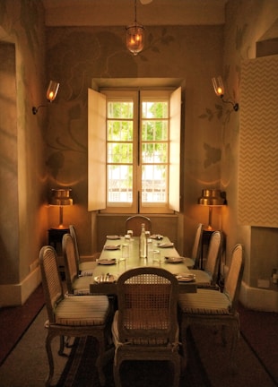 Elegant dining set with smooth oak finish surrounded by soft fabric chairs in a bright space.