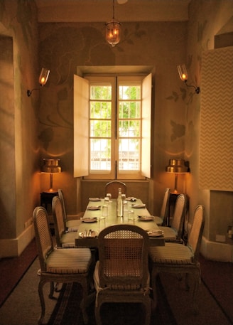 Elegant dining table made from mango wood, surrounded by matching chairs in a sunlit room.