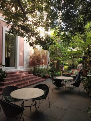A serene outdoor space with lush greenery and contemporary seating areas, perfect for relaxation.