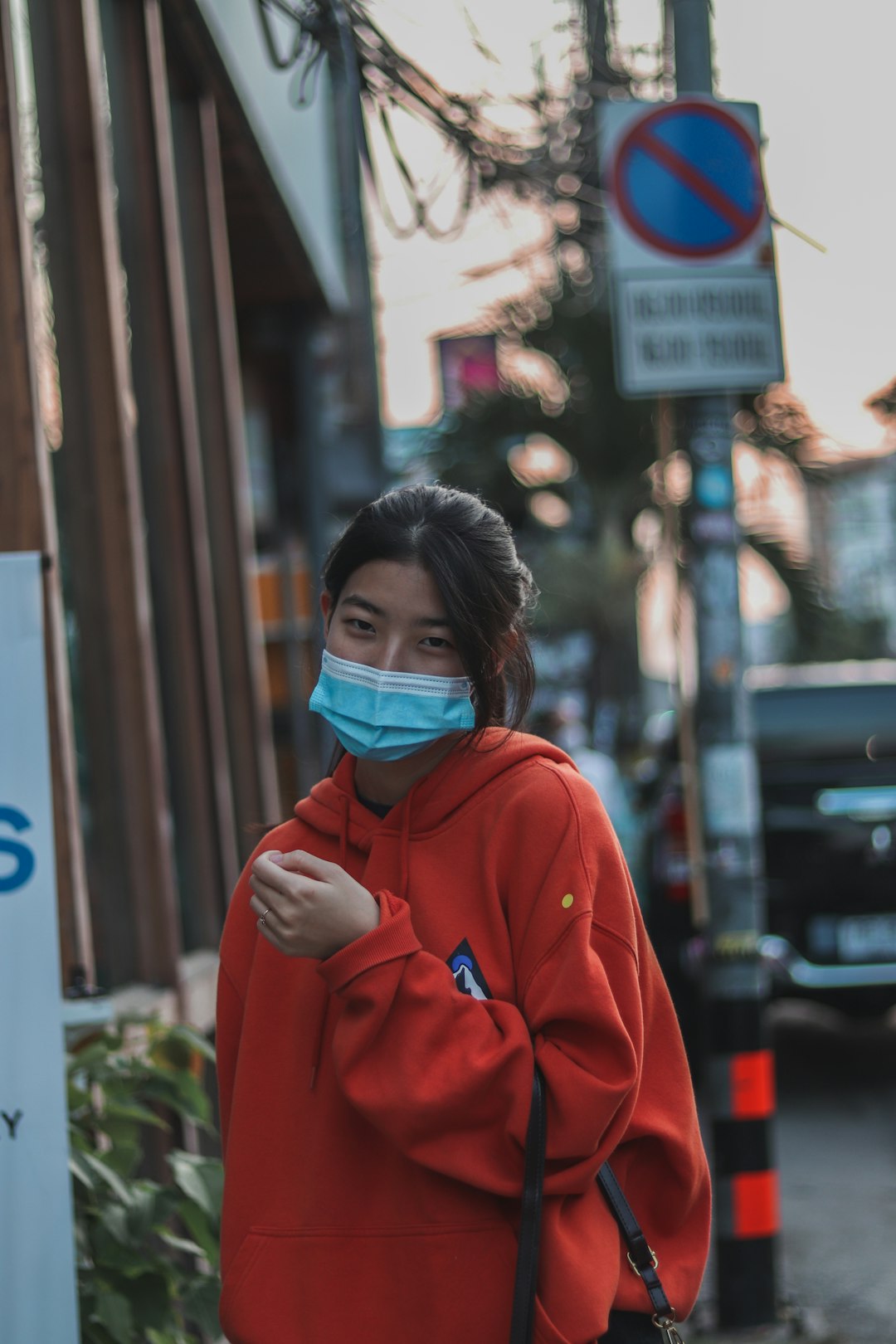 woman in red hoodie wearing blue mask